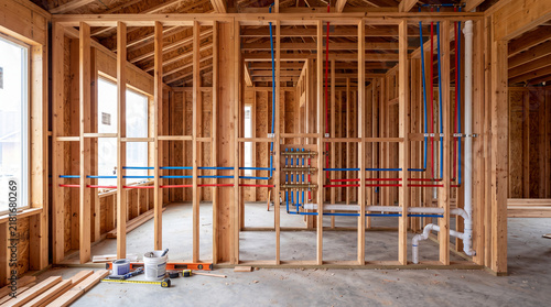 Interior View of a New Residential House Under Construction Featuring Detailed Wood Framing and Advanced PEX Plumbing Manifold System Installation