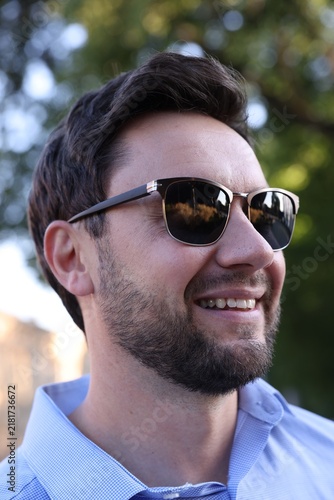 Handsome man wearing stylish sunglasses in park