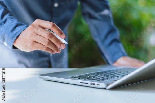 Foto Businessman Hand Pointing Pen at Laptop - Online Advisory, Virtual Mentorship, R