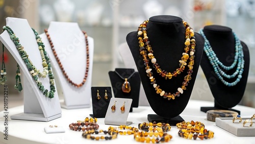 Amber and gemstone necklaces on display stands in a jewelry store