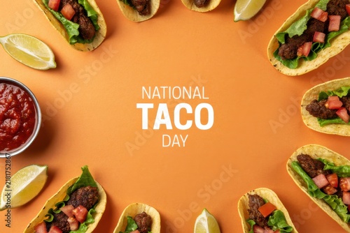 National taco day celebration with tacos, salsa and lime wedges on orange background
