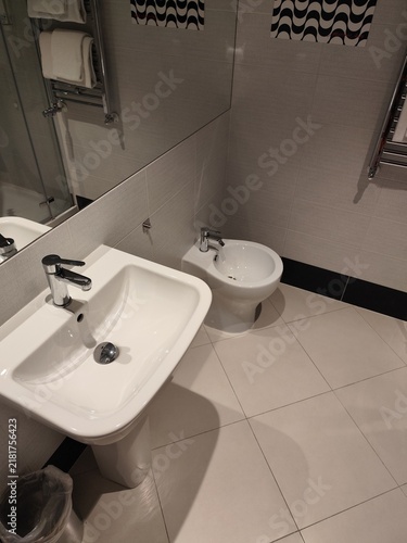 Foto Modern Bathroom Interior with Ceramic Sink, Bidet, and Tiled Floor at home