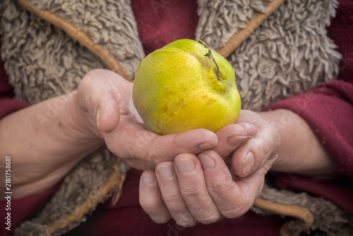 Senior longevity diet concept with elderly woman holding healthy organic quince fruit