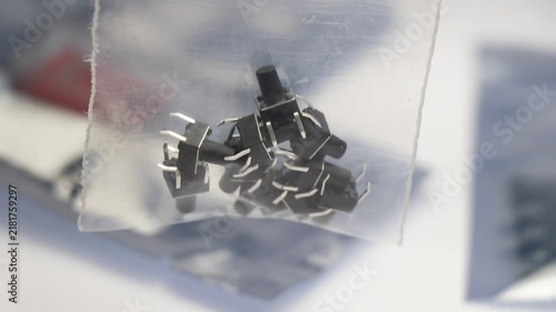 Tactile push-button switches with metal leads, packed in a clear plastic bag