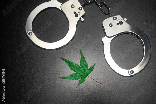 Cannabis and the Law Concept with Handcuffs and Marijuana Leaf