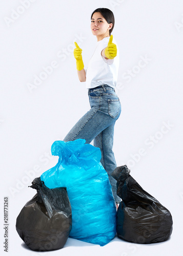 A woman with huge garbage bags is cleaning