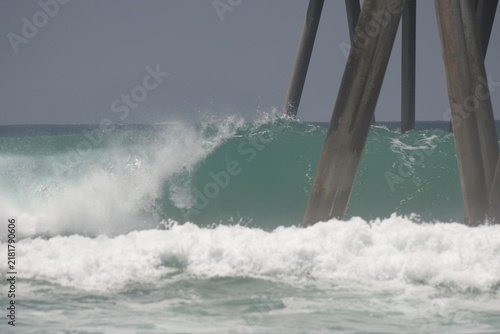 Photography Large swell waves breaking in the ocean on the pier pylons