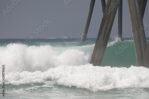 Photography Large swell waves breaking in the ocean on the pier pylons