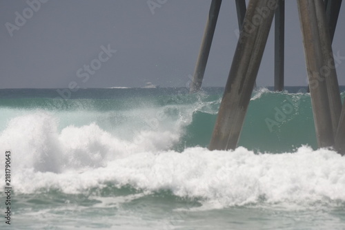 Photography Large swell waves breaking in the ocean on the pier pylons