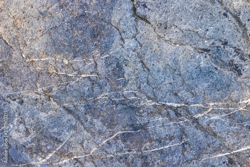 Blue hue granite stone with quartz veins as a natural background.