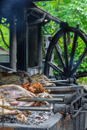 Whole Roasted Lamb On Spit Over Hot Coals At Traditional Outdoor Barbecue Roast