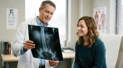 Doctor Explaining X-Ray Results To Smiling Patient