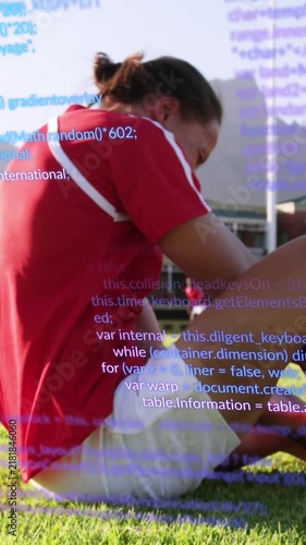 Animation of computer language over caucasian soccer player lying on ground in pain