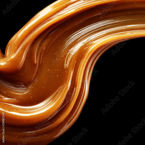 Flowing caramel sauce drips isolated on black background with clipping path, concept of sweetness and dessert texture