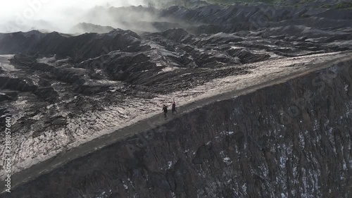 Two hikers exploring the dramatic, volcanic landscape of mount bromo crater in east java, indonesia