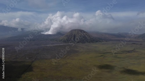 Aerial view of the active mount bromo volcano erupting smoke within the tengger caldera