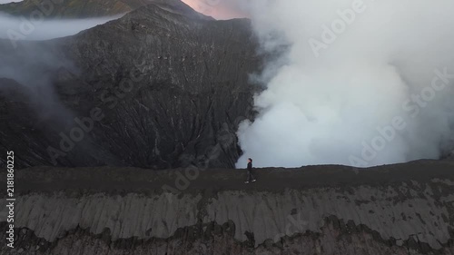 Aerial view of a man walking on the edge of the active bromo volcano crater in east java, indonesia