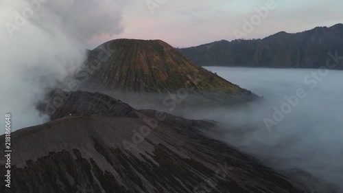 Aerial view of the active mount bromo volcano crater erupting in a sea of clouds in indonesia
