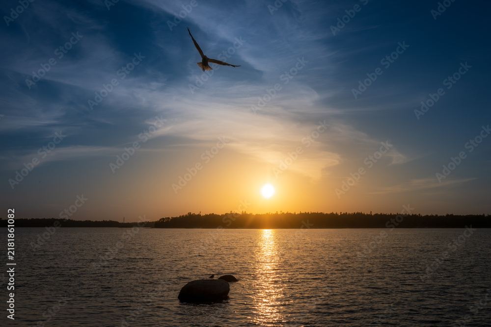 Fototapeta premium Late night sunset in Finland, the sun is setting over the sea.