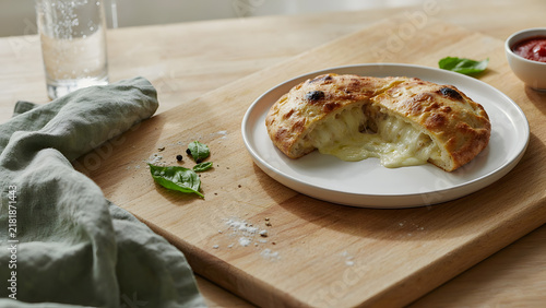 Fresh baked chicken calzone with melted cheese on a plate, created with generative ai
