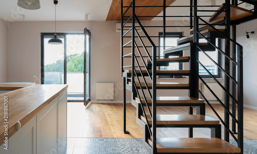 Modern architecture in design interior with stairwell with metal construction and wooden stairs. Contemporary and industrial room with space and window. New apartment. Real estate.