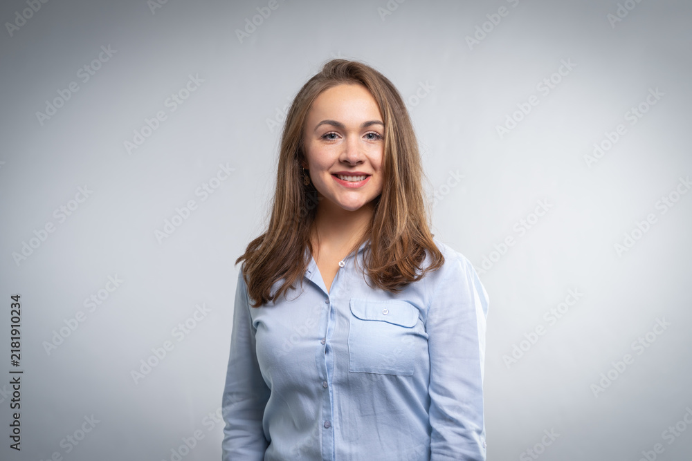 Fototapeta premium Young professional woman smiling headshot on gray background