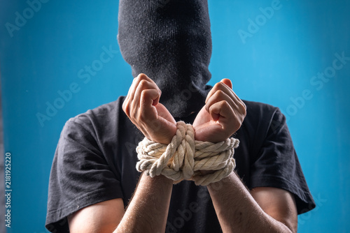 Bild auf Leinwand A man with his hands tied and a black bag on his head.