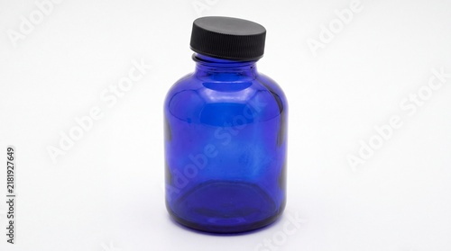 Konstfotografi Cobalt blue glass bottle with black screw cap, empty apothecary jar for essentia