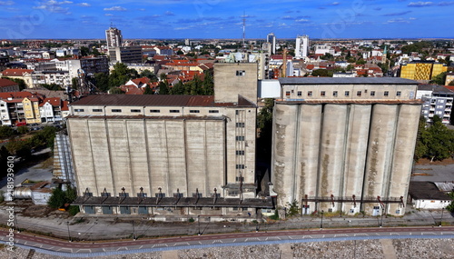 Aerial view of Silos Pancevo, a large industrial concrete grain silo complex with a tall central tower and cylindrical storage bins, near the waterfront in Pancevo, Serbia.