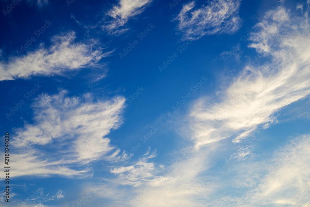 Fototapeta premium weightless white cirrus clouds scattered across a deep blue sky on a clear sunny day