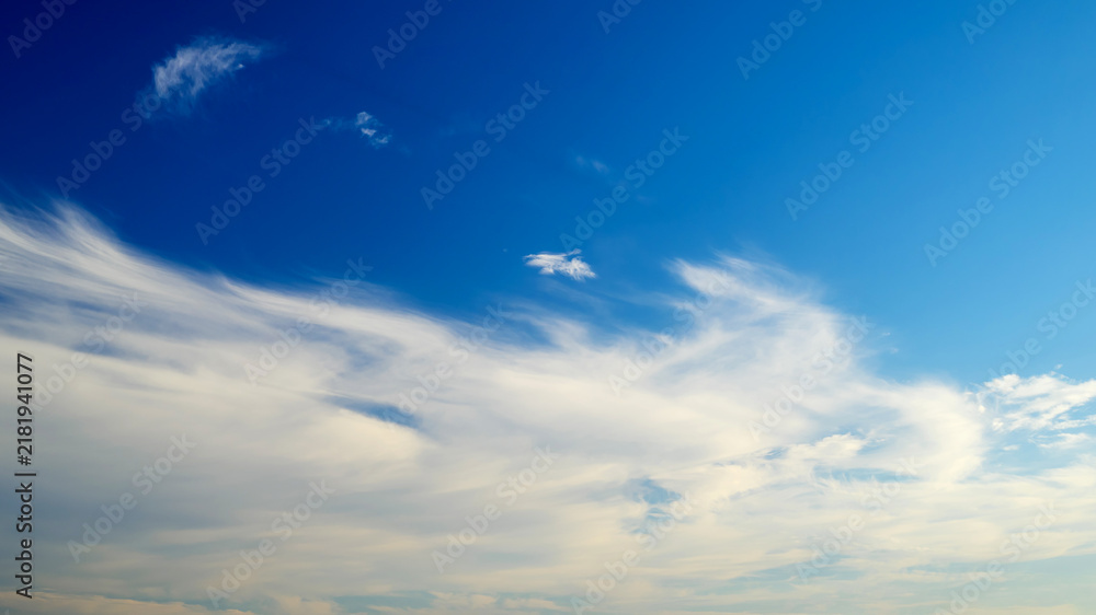 Fototapeta premium feathery white clouds scattered across the blue sky