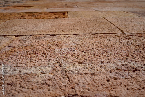 Ancient textured stone pavement with detailed rough surface showing natural erosion patterns in Barcelona