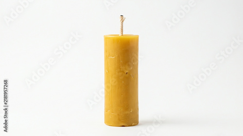 Yellow beeswax candle standing isolated on white background for spa and home decor