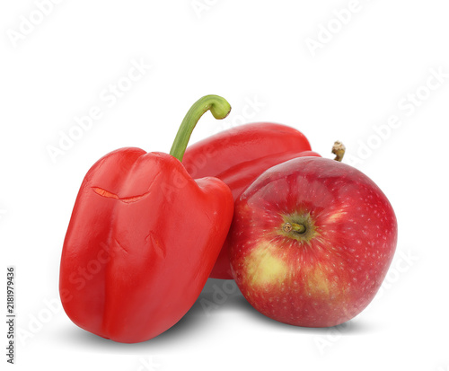 two red bell peppers next to an apple