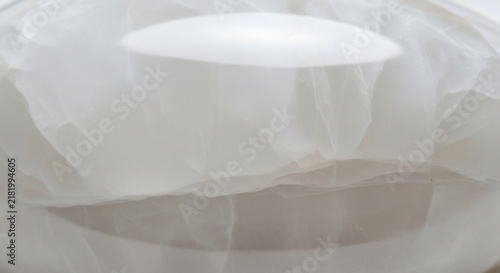 Fabric layers form a delicate white abstract structure with soft folds and smooth translucent textures.