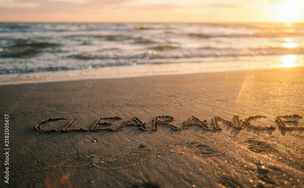 Obraz premium Clearance text written in wet sand on a tropical beach at sunset for retail sales and commercial shopping promotions