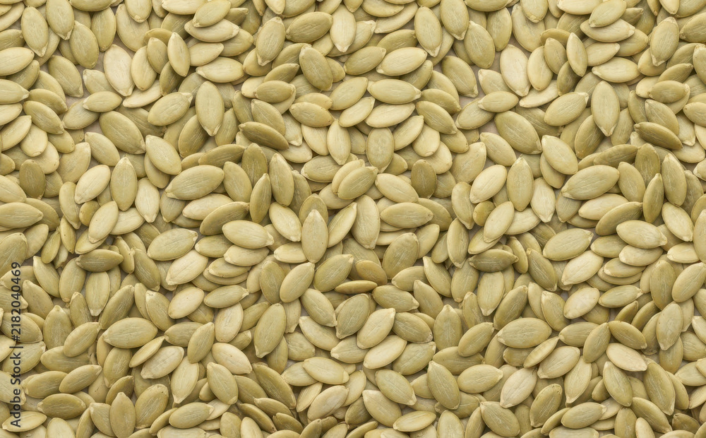 Obraz premium A background texture of healthy organic pumpkin seeds spread evenly as a nutritious snack concept for healthy eating and vegetarian diet themes