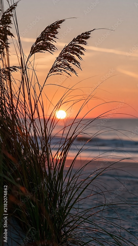 Obraz premium Golden Sunset Over Ocean Waves with Silhouetted Sea Oats on Sandy Beach