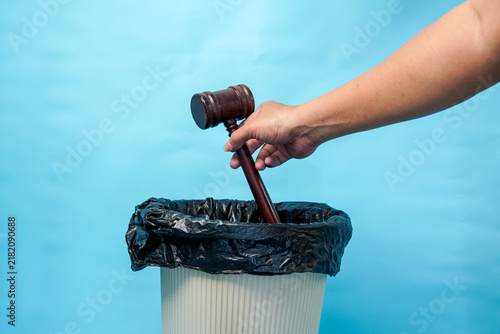 Картината върху платно Hand throwing a wooden judge gavel into a trash bin representing legal system failure