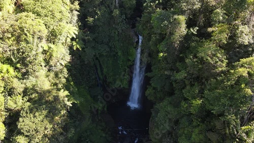 Aerial footage of Cidadap Waterfall Surrounded by Wild Banana Trees and Dense Tropical Vegetation During Morning in Indonesia. Forest and the Flowing Cascade Create Vibrant Nature in the Wilderness.