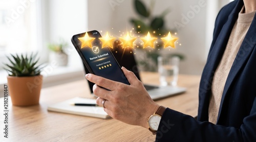 Business professional holding smartphone displaying five golden stars rating review submitted feedback screen, customer satisfaction, positive user experience, mobile app