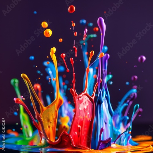 Explosion of vibrant, colorful liquid paint splashes frozen in motion against a dark