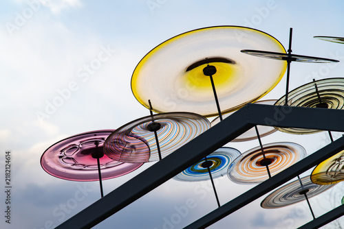 Colorful Swirling Glass Discs Art Installation Against Cloudy Sky
