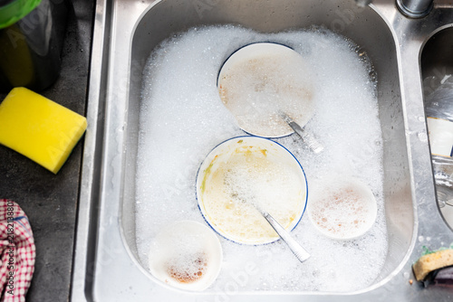 Fotografía kitchen sink full of soapy water and dishes