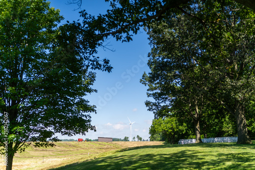 Cuadro en lienzo Wind turbine beyond shaded rural farmland
