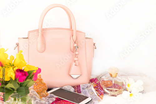 pink bag, perfume, scarf and mobile phone of lifestyle woman relax autumn season arrangement flat lay style on background white 
