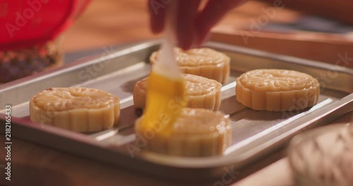 Brushing egg liquid on handmade mooncake for Mid‑Autumn Festival