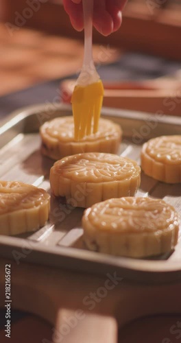 Brushing egg liquid on handmade mooncake for Mid‑Autumn Festival