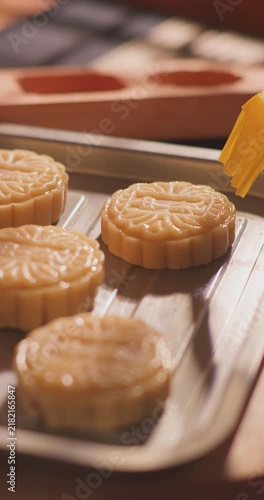Brushing egg liquid on handmade mooncake for Mid‑Autumn Festival