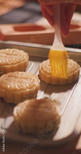 Brushing egg liquid on handmade mooncake for Mid‑Autumn Festival